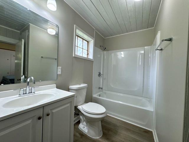 full bathroom featuring wooden ceiling, tub / shower combination, hardwood / wood-style floors, toilet, and vanity