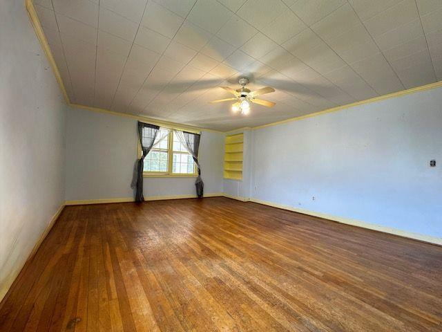 unfurnished room with ceiling fan, hardwood / wood-style floors, and crown molding