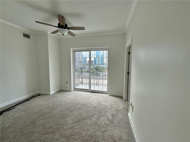 carpeted spare room featuring crown molding, ceiling fan, and a textured ceiling