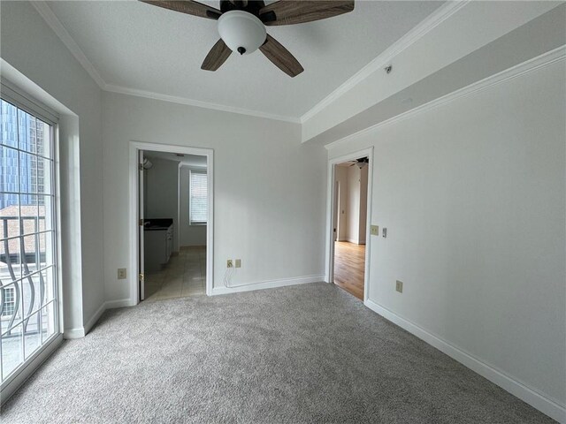 unfurnished bedroom featuring access to exterior, ceiling fan, crown molding, and light carpet