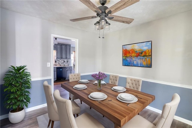 dining space with ceiling fan and dark hardwood / wood-style flooring