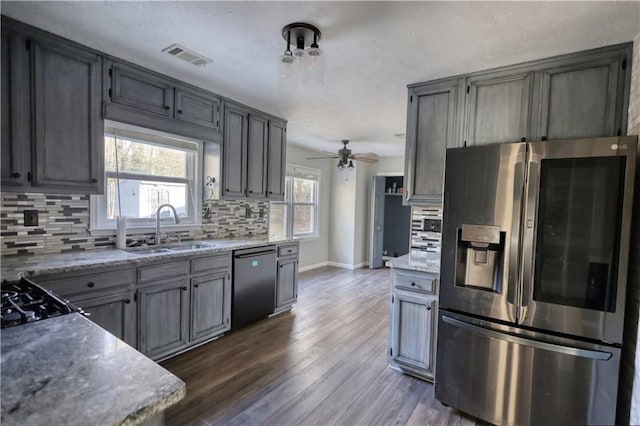 kitchen with sink, dishwasher, dark hardwood / wood-style floors, stainless steel fridge with ice dispenser, and decorative backsplash