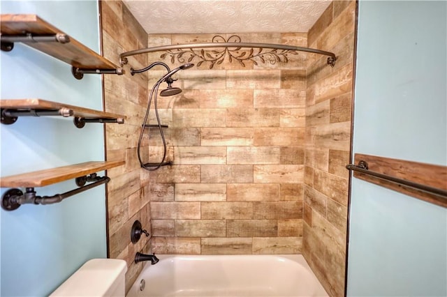 bathroom featuring tiled shower / bath combo and a textured ceiling