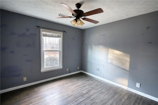 empty room with hardwood / wood-style flooring, a textured ceiling, and ceiling fan