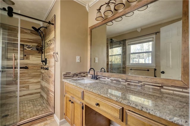 bathroom featuring walk in shower, tasteful backsplash, crown molding, vanity, and tile patterned flooring