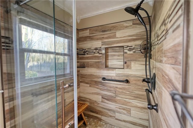 bathroom featuring ornamental molding and tiled shower