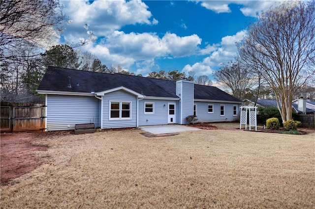 rear view of property featuring a yard and a patio area