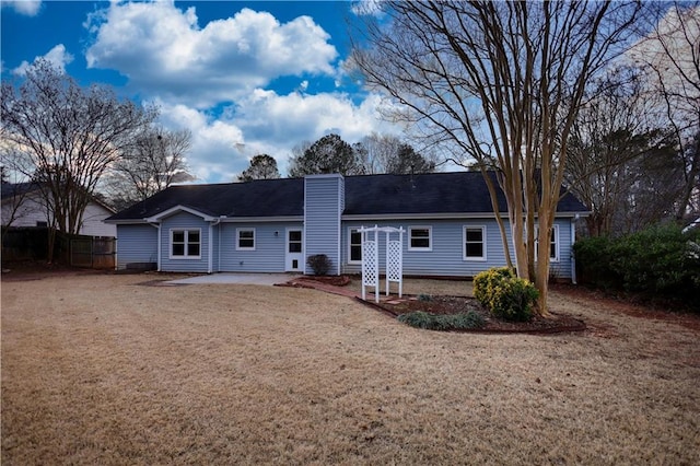 back of property featuring a patio and a lawn