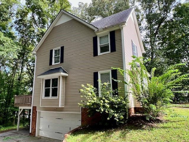 view of side of home featuring a garage and a deck