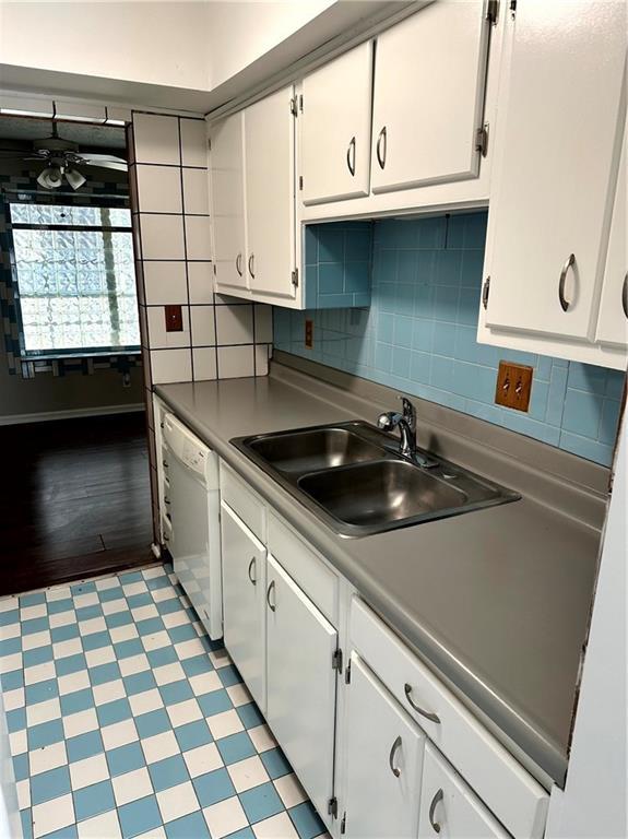 kitchen with decorative backsplash, a ceiling fan, dishwasher, a sink, and white cabinetry