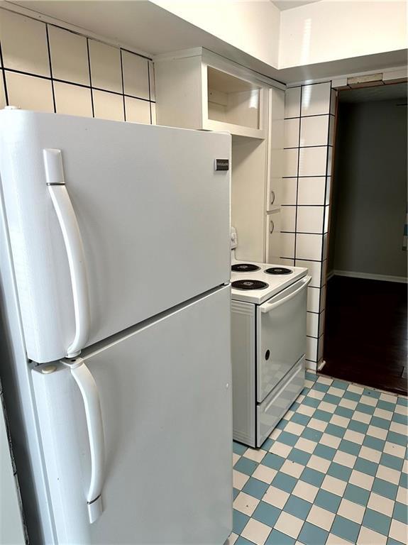 kitchen featuring light floors and white appliances