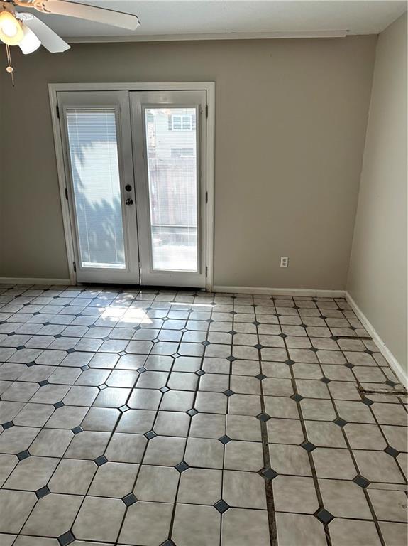 unfurnished room featuring baseboards, ceiling fan, and french doors