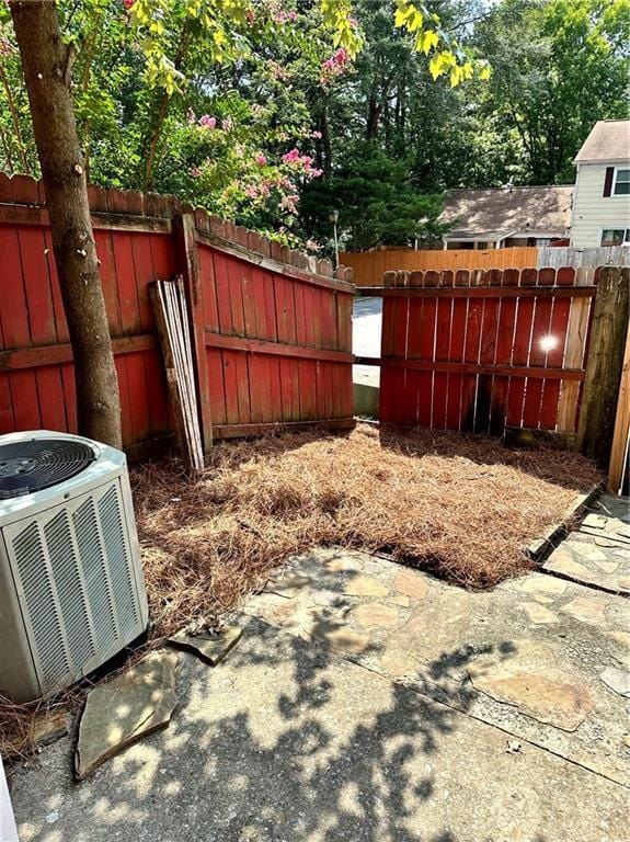 view of yard featuring central AC, a fenced backyard, and a patio area