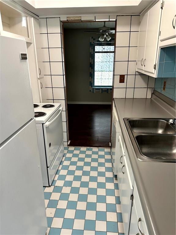 kitchen with ceiling fan, backsplash, a sink, white cabinets, and white appliances