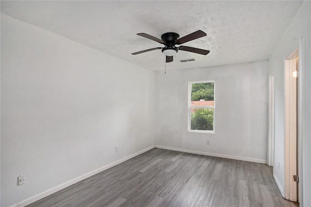 unfurnished room featuring ceiling fan, light hardwood / wood-style floors, and a textured ceiling