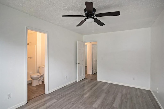 unfurnished bedroom with a textured ceiling, light wood-type flooring, ceiling fan, and ensuite bathroom