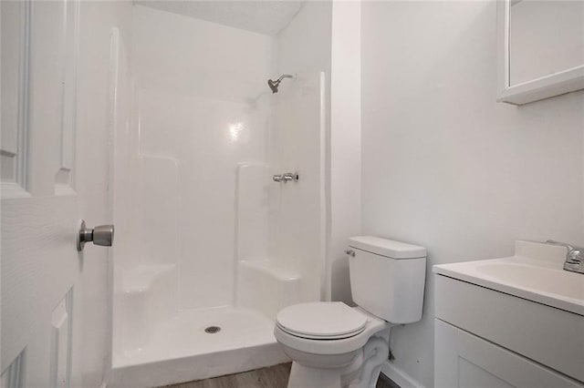 bathroom featuring vanity, hardwood / wood-style floors, toilet, and walk in shower