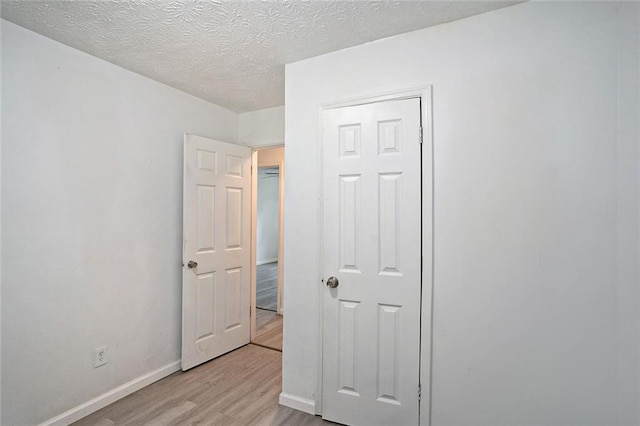 bedroom featuring light hardwood / wood-style flooring and a textured ceiling