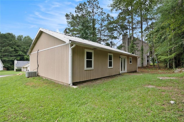 view of side of home featuring central air condition unit and a lawn