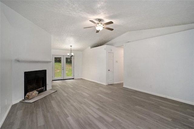 unfurnished living room with hardwood / wood-style flooring, lofted ceiling, ceiling fan with notable chandelier, and a textured ceiling