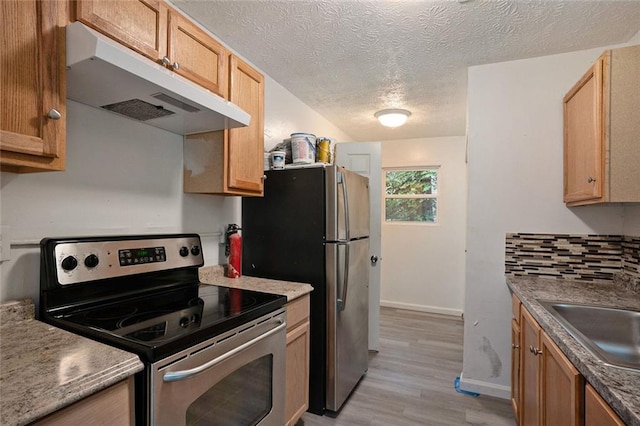 kitchen featuring appliances with stainless steel finishes, tasteful backsplash, sink, light hardwood / wood-style floors, and a textured ceiling