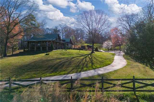 view of community featuring a yard and fence