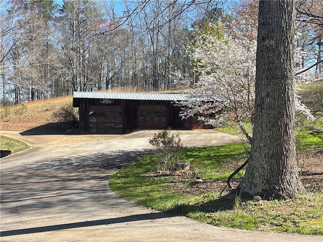 exterior space with a garage, driveway, and an outdoor structure