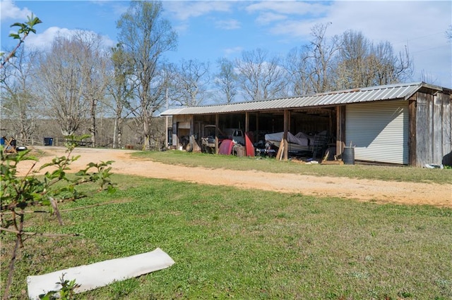 view of pole building featuring a carport, a yard, and driveway