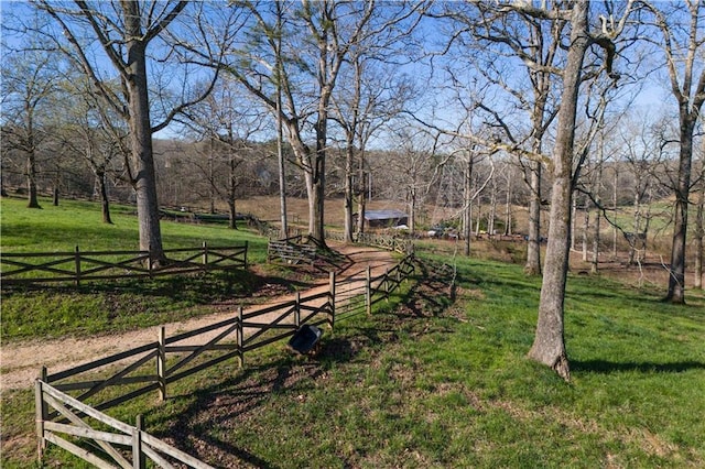 view of yard with fence and a rural view