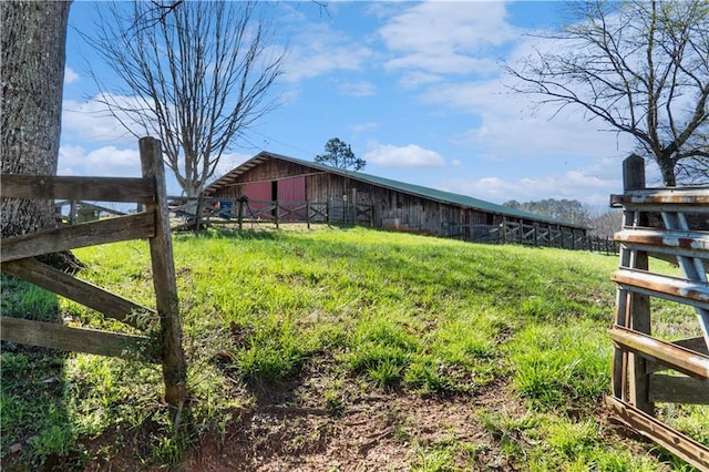 view of yard with an outbuilding, fence, and an outdoor structure