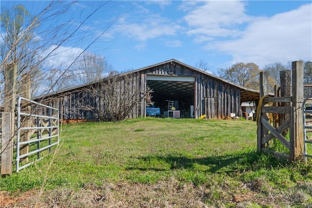 view of pole building featuring a lawn and fence