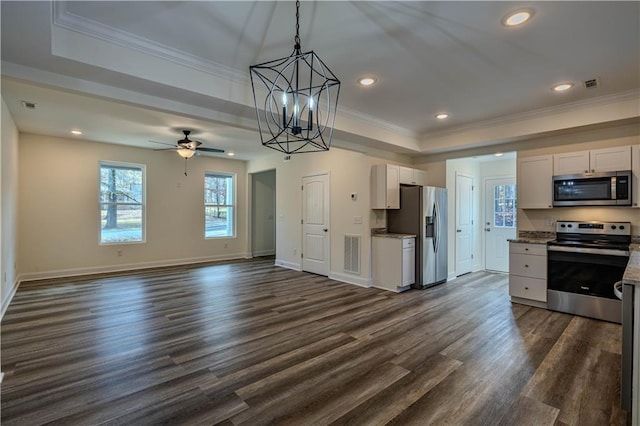 kitchen with dark wood-type flooring, white cabinets, ceiling fan with notable chandelier, ornamental molding, and stainless steel appliances