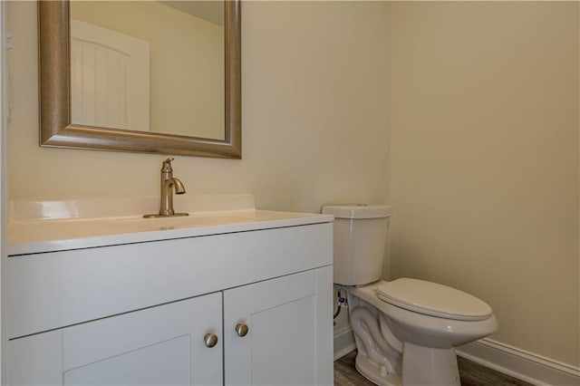 bathroom featuring vanity, hardwood / wood-style flooring, and toilet