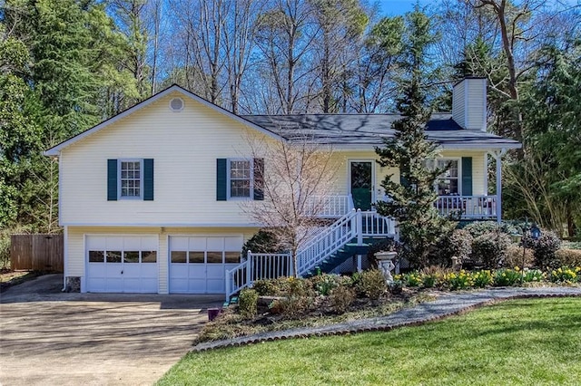 view of front of house featuring an attached garage, covered porch, a chimney, stairs, and concrete driveway