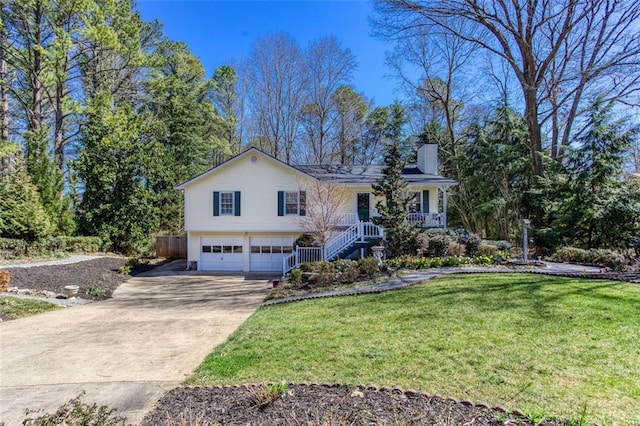 view of front facade with a front lawn, stairs, a chimney, a garage, and driveway