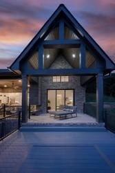 back house at dusk featuring a patio