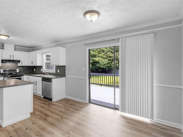 4720 Hull Rd, Conyers, GA 30094 - kitchen with appliances with stainless steel finishes, a textured ceiling, dark countertops, under cabinet range hood, and white cabinetry