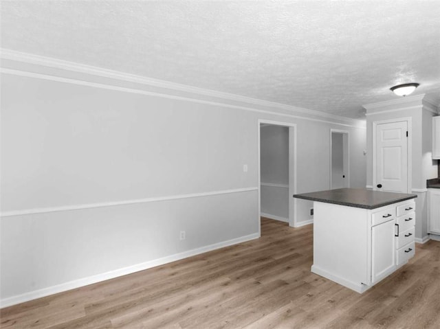 4720 Hull Rd, Conyers, GA 30094 - kitchen featuring dark countertops, white cabinets, light wood finished floors, ornamental molding, and a textured ceiling