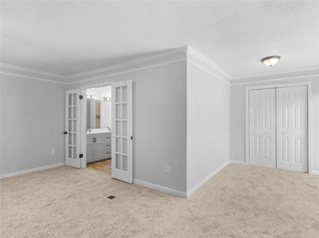 4720 Hull Rd, Conyers, GA 30094 - unfurnished bedroom featuring french doors, light colored carpet, a textured ceiling, crown molding, and connected bathroom