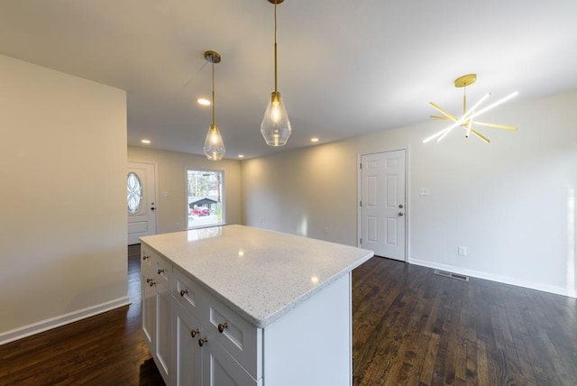 kitchen with pendant lighting, dark wood-style floors, a center island, white cabinetry, and baseboards