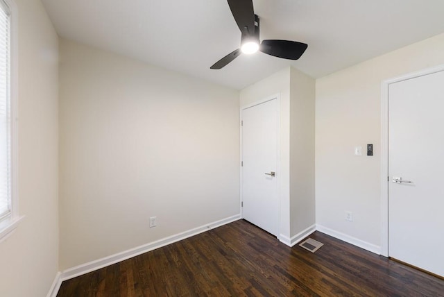 unfurnished bedroom with visible vents, ceiling fan, baseboards, and dark wood-style flooring