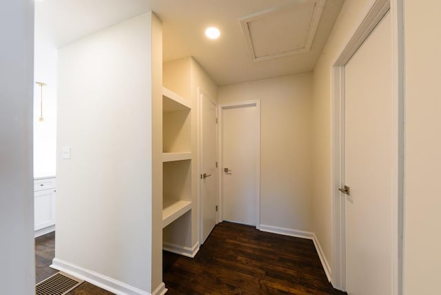 hall featuring visible vents, attic access, baseboards, and dark wood-style flooring