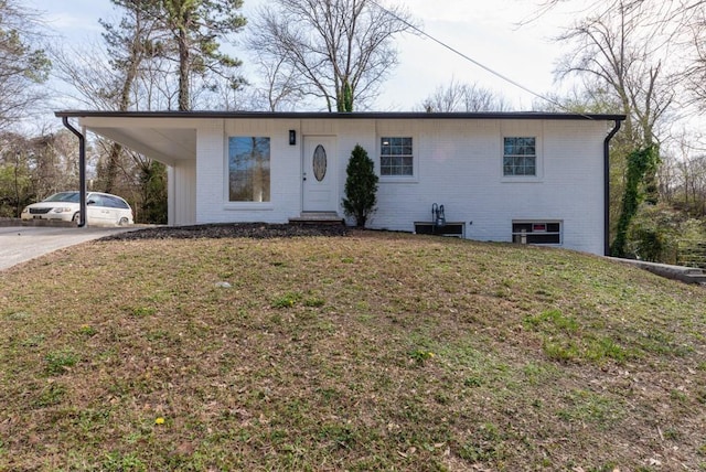 ranch-style home featuring brick siding, concrete driveway, and a front yard