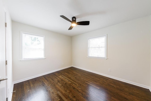 unfurnished room featuring dark wood finished floors, a ceiling fan, and baseboards