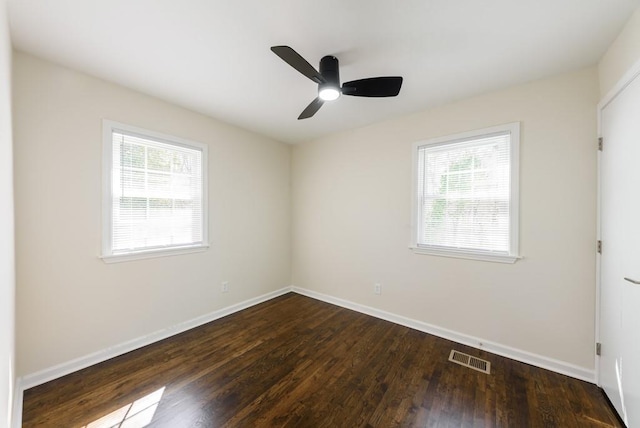 spare room with visible vents, wood finished floors, baseboards, and ceiling fan