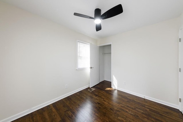 unfurnished bedroom featuring visible vents, a ceiling fan, wood finished floors, a closet, and baseboards