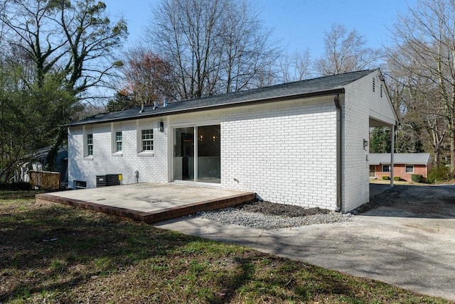 back of house featuring brick siding and a deck