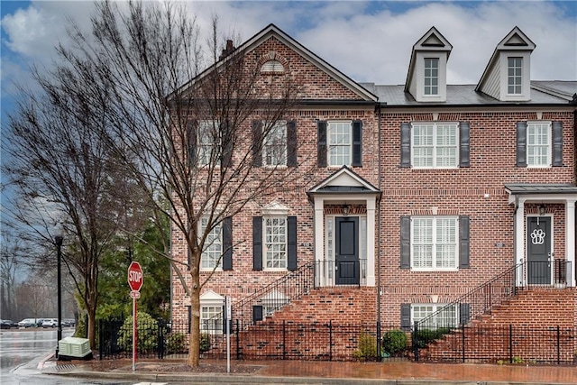 view of front of home featuring a fenced front yard and brick siding