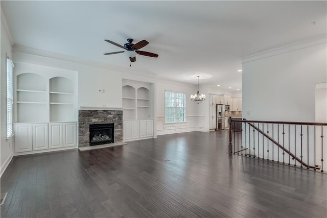 unfurnished living room featuring a fireplace, built in shelves, dark wood-style floors, and ornamental molding