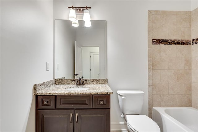 full bathroom featuring vanity, tiled shower / bath, and toilet